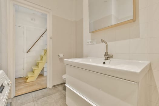 a bathroom with a sink, mirror and toilet paper dispensed on the wall next to the door