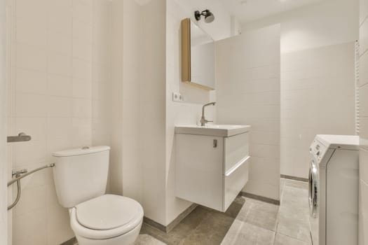 a bathroom with white tiles on the walls and toilet in the middle, there is a mirror over the sink