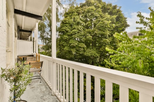 a balcony with white railings and green trees in the background, on a sunny day at an apartment building