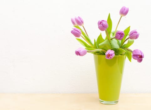 Pink Tulips Bouquet in Green Glass Vase on Wooden Table