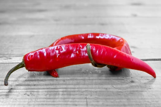 two Chili peppers on the wooden floor