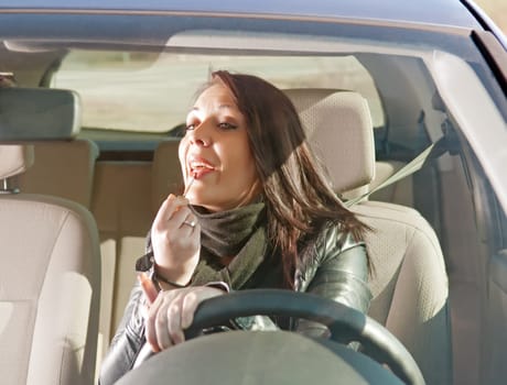 Young woman with lipstick in car