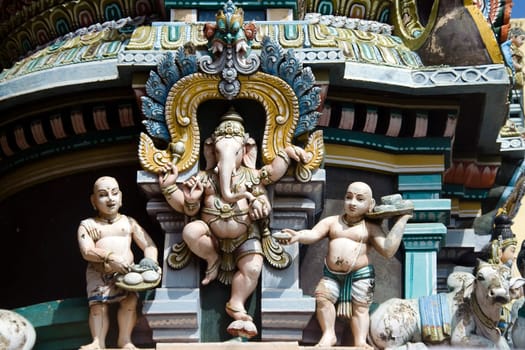 Statue of dancing Ganesha flanked by devotees offering delicious food on Gopura of Jambkeshwara Temple, Tiruchirapalli, Tamil Nadu, India, Asia