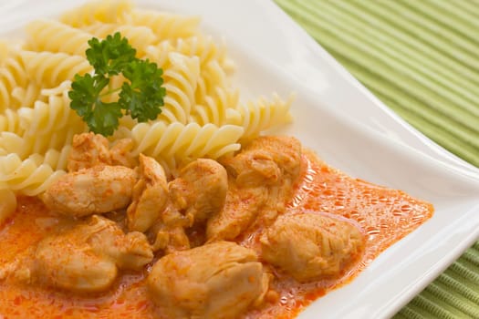 Chicken pieces with Pasta in Paprika Cream Sauce. Decorated with parsley.