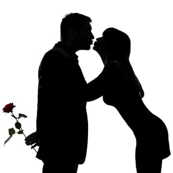 one caucasian couple man and woman kissing in studio silhouette isolated on white background