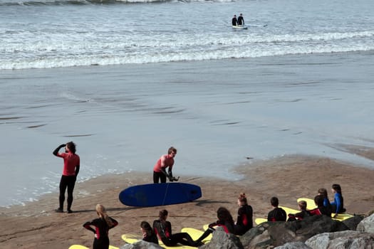 surfing school students being taught on the beach in lahinch county clare ireland on a beautiful day