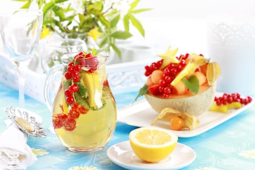 Delicious fresh fruits served in melon bowl as dessert with lemonade