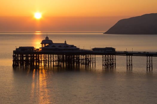Golden Sunrise over the historic pier in Llandudno Wales
