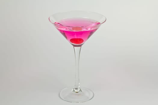 Pink martini cocktail with a cherry garnish