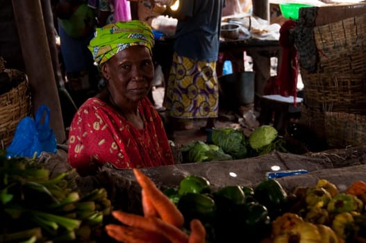 Shopkeeper selling vegetables at the local market in Bamako, Mali