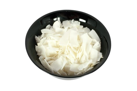 Black bowl full of coconut chips, isolated on white