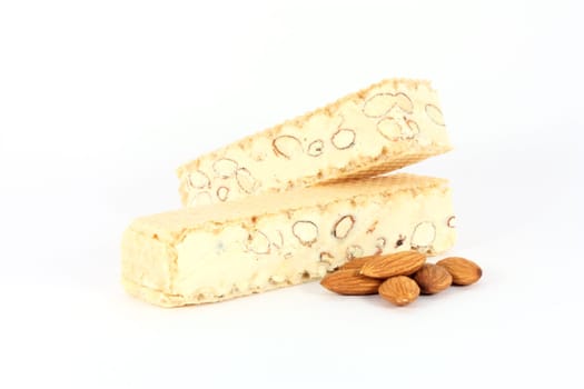 Almond nougat with some almonds, isolated on white