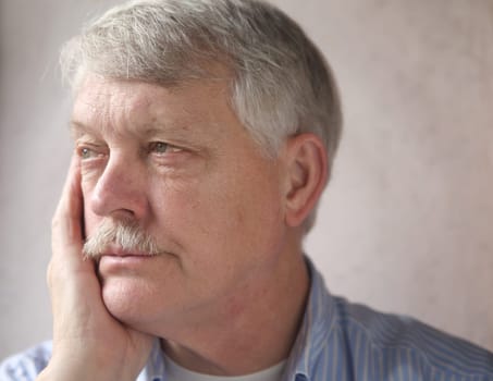 businessman rests his head on his hand, looks irritated