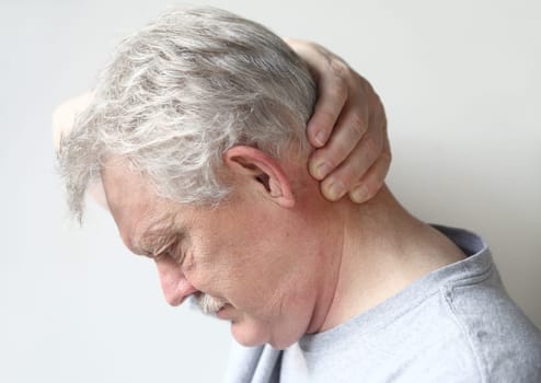 senior man with a hand at the back of his head