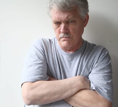 angry older man with his arms crossed