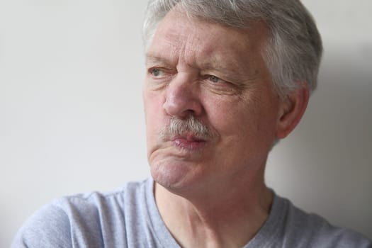 an older man twists his mouth to one side
