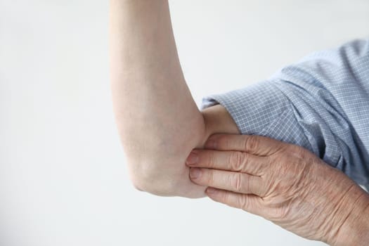 a man indicates where the pain is located in his arm