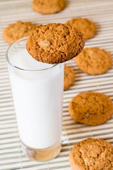glass of fresh milk and oat cookies on the table