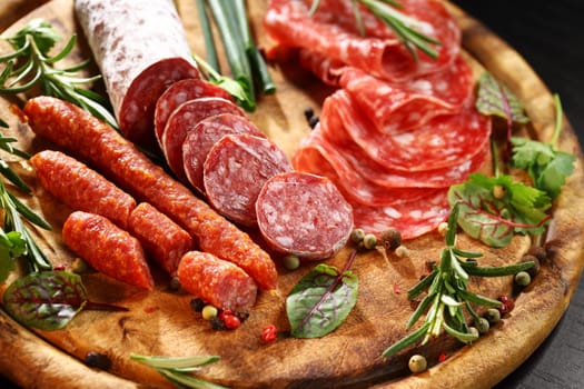 Different Italian ham and salami with herbs