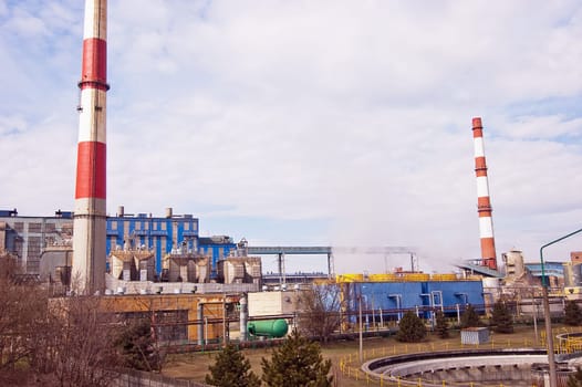 With a smoking chimney power plant on a sunny day