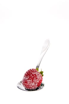 Fresh strawberries dipped in sugar on a spoon