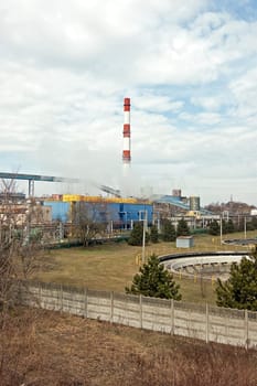 With a smoking chimney power plant on a sunny day