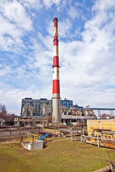 With a smoking chimney power plant on a sunny day