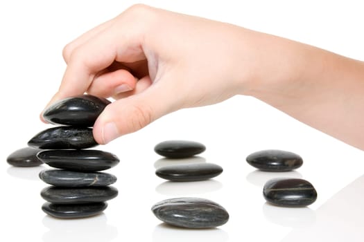 Building a Zen garden. hand and stones on white background.