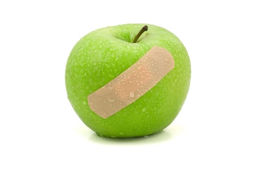 green injured apple with plaster,isolated on white background