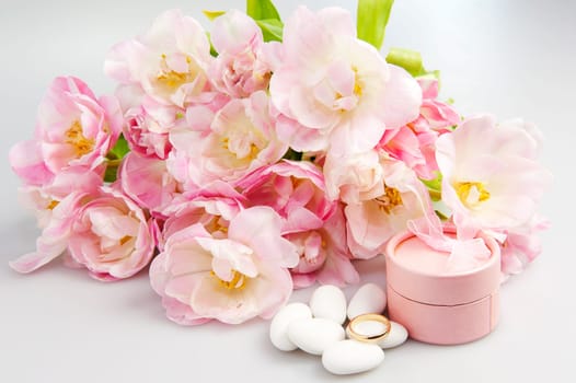 Composition of mottled pink tulips and wedding rings