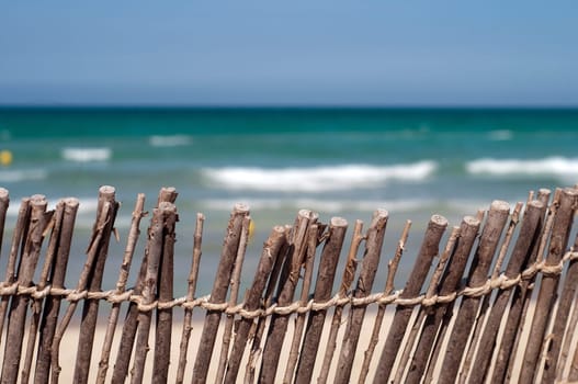 Beach shot: blue sea, sand and fence