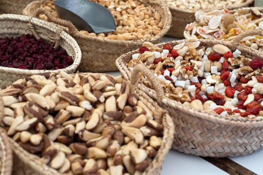 Different nuts in baskets on market, snack