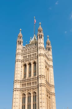One of the towers of Houses of Parliament in London, UK, with British Union flag atop.