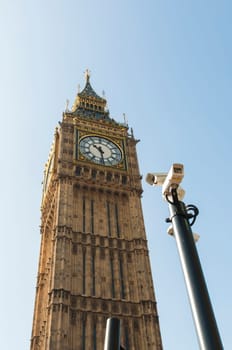 Low angle shot of Big Ben in London, with security cameras in the foreground.