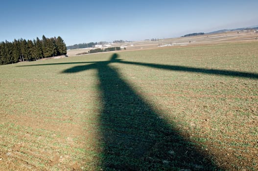 Shadow of a wind turbine on a field