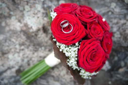 Bridal bouquet made with red roses with wedding rings