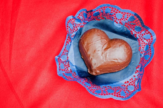 Heart shaped valentines day chocolate cake on red paper