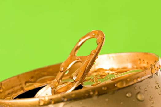 opened can of cold beer on green background