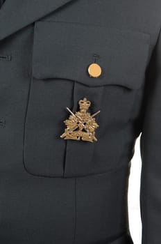 A closeup of a olive green uniform jacket with a medal on the pocket.
