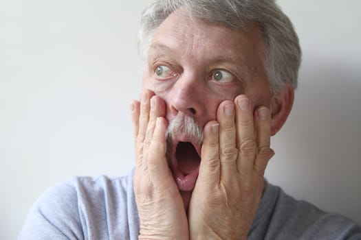 an older man is horrified and fearful
