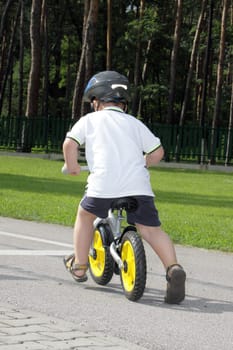 Baby boy on traffic playground for childs with crash helmet