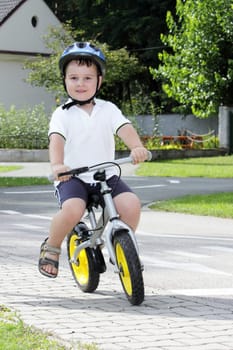 Baby boy on traffic playground for childs with crash helmet