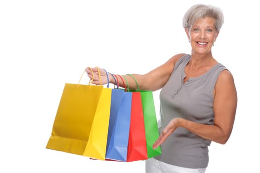Studio shot of active senior woman with shopping bags