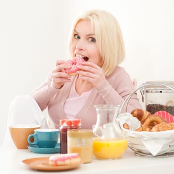 Young and blonde woman sitting at a breakfast table