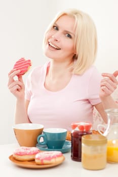 Young and blonde woman sitting at a breakfast table
