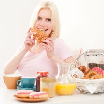 Young and blonde woman sitting at a breakfast table