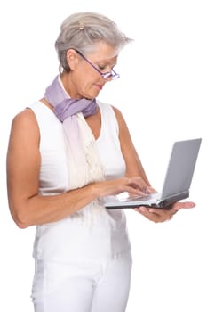 Studio shot of an active senior woman using a notebook