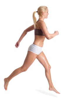 Young woman jogging in front of light background