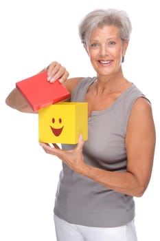 Studio shot of an active senior woman with a box
