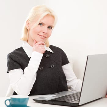 Young businesswoman sitting at desk with computer